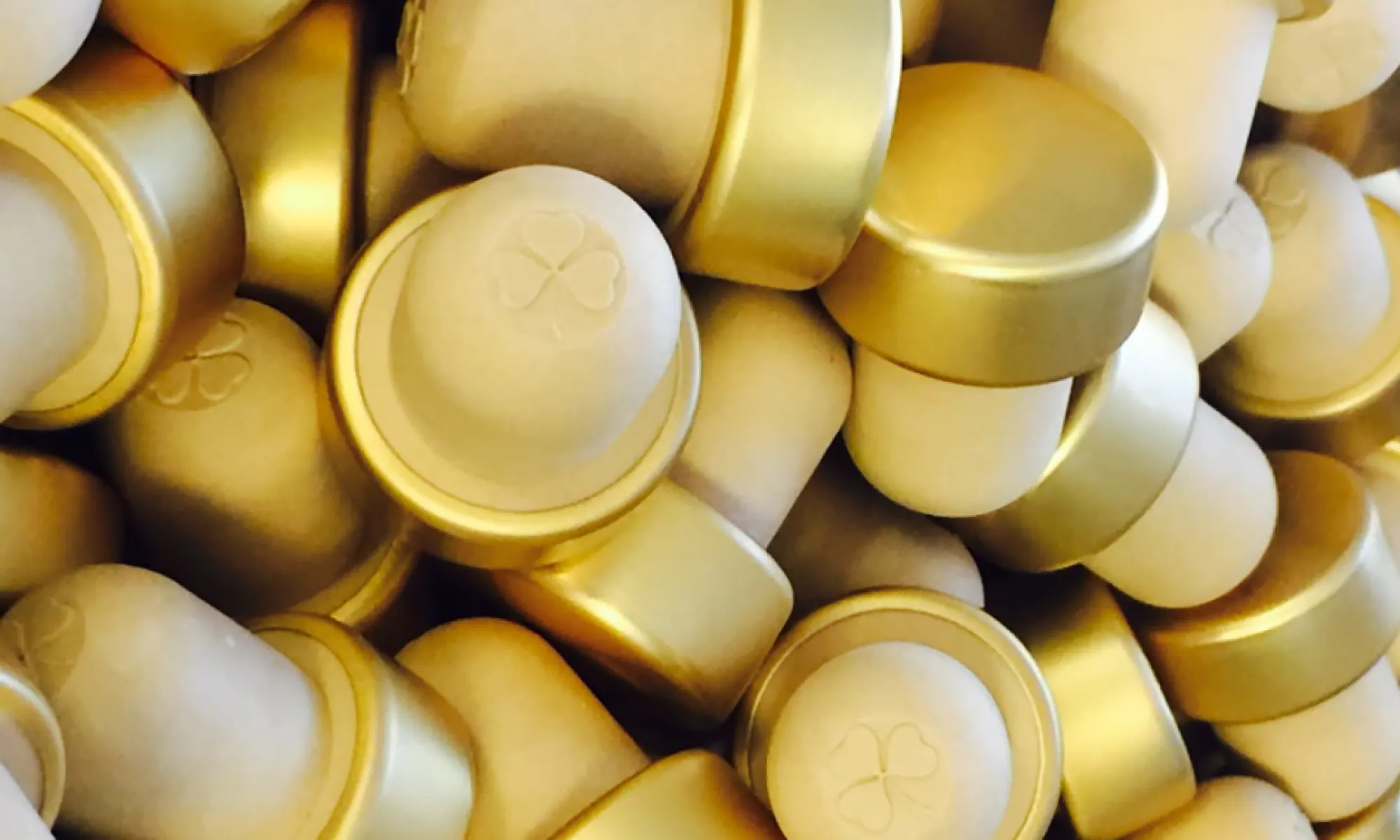 Gold Bonn Óir bottle stoppers, each embossed with a shamrock