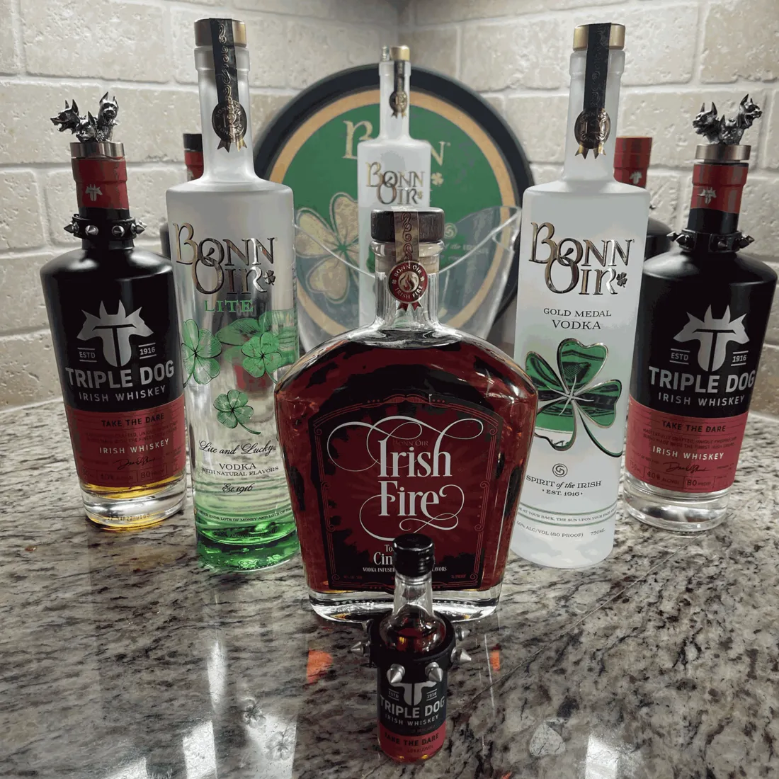 The O'Shevlin range on a granite counter: Triple Dog Irish Whiskey, Bonn Óir Lite, Irish Fire, Gold Medal Vodka and a Triple Dog miniature